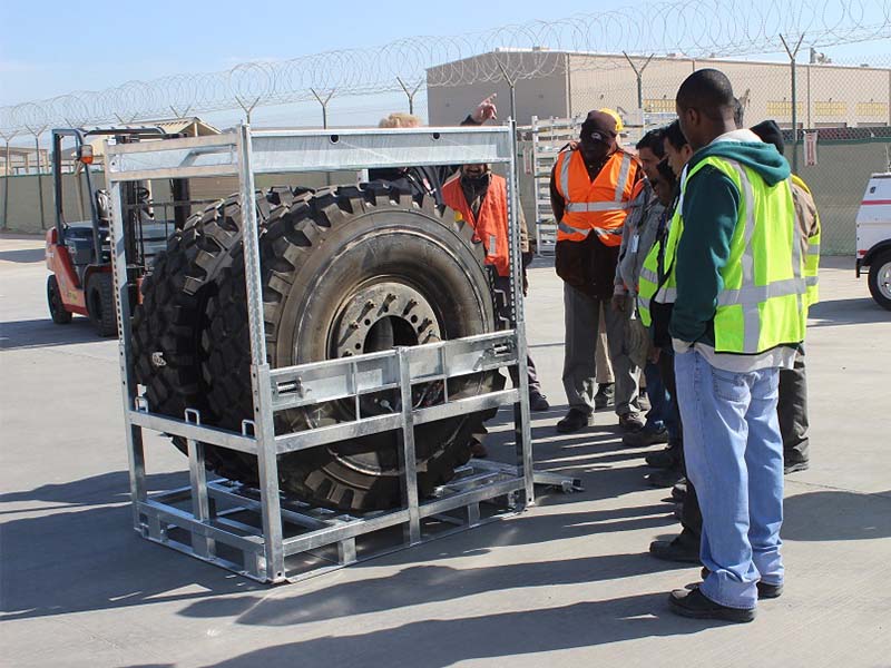 Stackable wheel cage WST II with warehouse workers around.